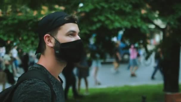 Masked face of guy in crowd of political opposition of coronavirus restrictions. — Stock Video