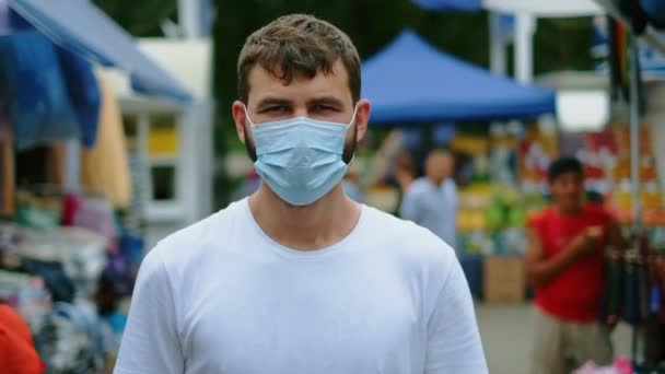 コロナウイルスの男はアジア市場をマスク歩くと、パンデミック通りのショッピングはありますか — ストック動画