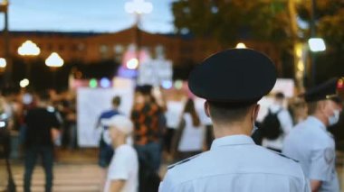 Yüzü maskeli ve üniformalı bir polis memuru protesto yürüyüşünün güvenliğini sağladı.