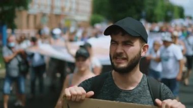 Muhalif insanlar şehir yürüyüşünde. Kalabalık grev. Erkek eylemci portresi haykırıyor