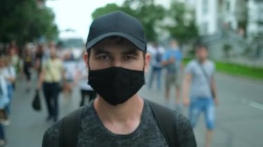 Muhalif kişi, covid salgın kısıtlamaları altında yüz maskesi takarak protesto ediyor.