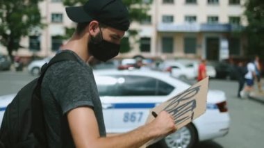 Maskeli çevik kuvvet eylemcisi afiş çiziyor, afiş asıyor. Asiler toplanıyor..