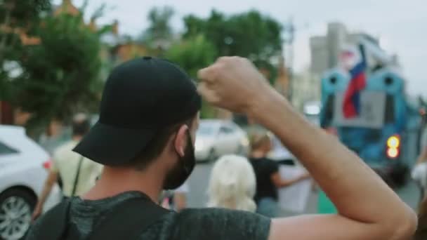 Protestant person vinkar arm knytnäve i upplopp rally publiken under covid restriktioner. — Stockvideo