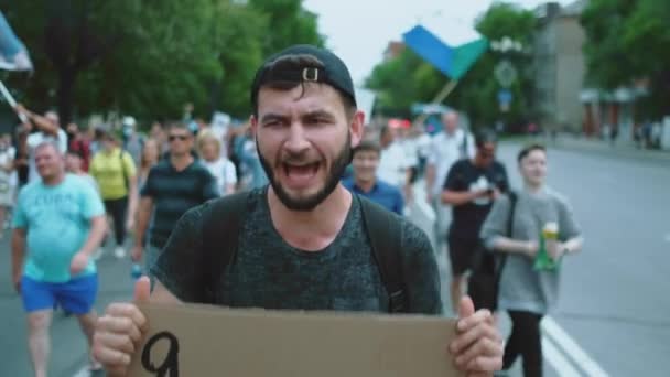 Protesting city street. Resistance activist man with banners, placards and sign. — Stock Video