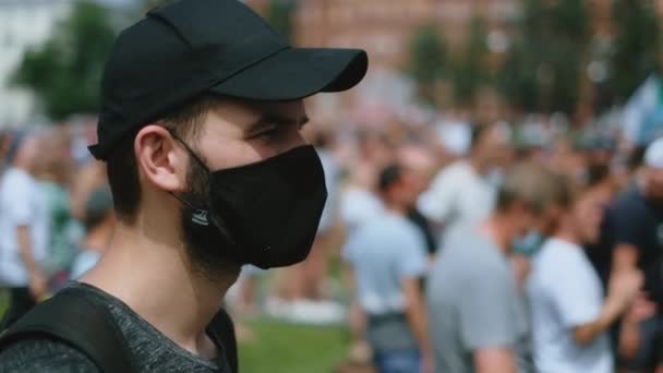 Man anti pandemiska restriktioner aktivist i svart facemask på strejk rally. — Stockvideo