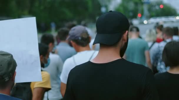 Attivista di protesta barbuto che marcia sul picchetto della rivolta. La gente cammina con striscioni. — Video Stock