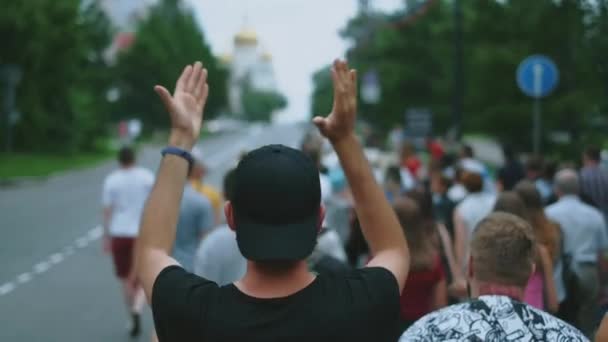 Manifestante pacífico aplaude mientras marcha con gente de la oposición en multitud — Vídeos de Stock