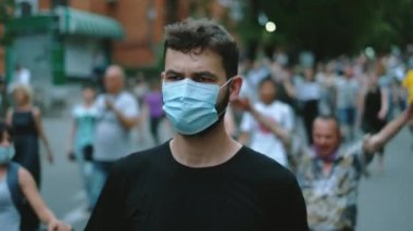 Siyahi maskeli bir protestocu kısıtlamalarla yürüyor..