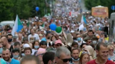 Khabarovsk sokaklarında pankartlar ve pankartlarla yürüyüş yapan protestocular.