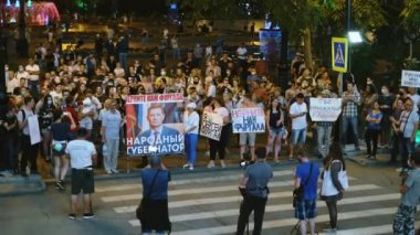 Eylemcilerin barışçıl kalabalığı protesto pankartları ve pankartlarıyla ayakta duruyor.