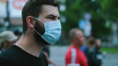 Covid-19 tecrit yasağı grevi, muhalefet mitinginde maskeli adam.