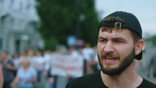 Demonstrator facet z brodą spacery i krzyki w tłumie opozycji politycznej — Wideo stockowe