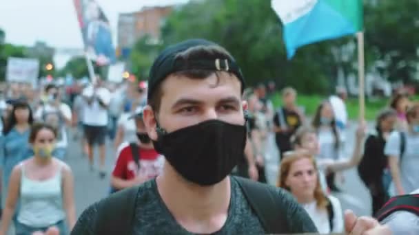 Aktivist kille med maskerat ansikte på politisk rally med opposition banner skylt. — Stockvideo