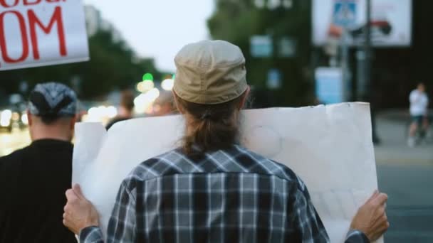 Rowerzyści maszerują z plakatami i plakatami. Protestujący w bandanie — Wideo stockowe