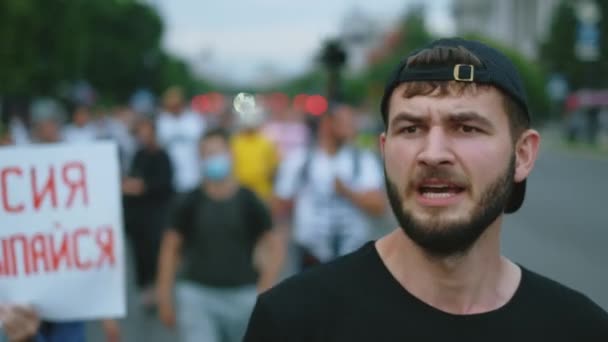 Motstånd picketing man rebell vågor hans arm och promenader i protesterande grupp. — Stockvideo