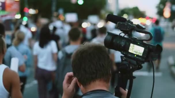 Operador de cámara de video filma rebeldes con carteles en demostración de resistencia — Vídeos de Stock