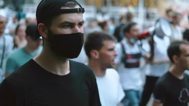 Anti-Covid-19-Regeln-Kundgebung, Protestierer mit Gesichtsmaske, Ochsenhorn im Hintergrund. — Stockvideo