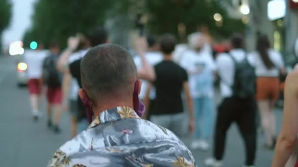 Protestante em máscara facial artesanal andando na multidão de rali durante o protesto covid-19. — Vídeo de Stock