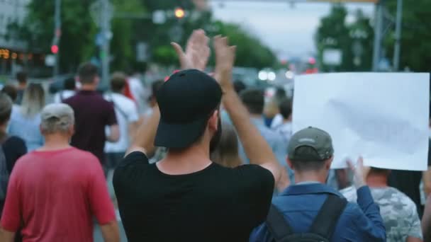 Ellenállás lázadók sétálnak és menetelnek a város utcáin zsúfolt zavargások. A személy tapsol. — Stock videók