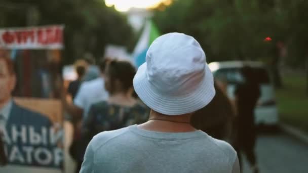 Activista masculino con sombrero de cubo marchando en rebelión multitud rebelde con pancartas. — Vídeos de Stock