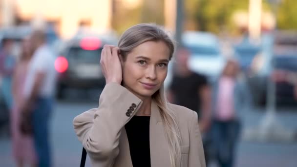 Retrato de la encantadora mujer rubia de la ciudad con pose de moda mirando a la cámara. — Vídeo de stock