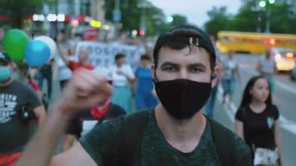 Protestant personne vagues bras poing dans émeute foule de rassemblement sous des restrictions covid. — Video