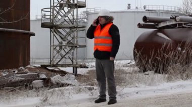 Petrol Tankları yakın smartphone cep telefonu ile konuşurken mühendisi