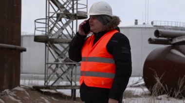 Petrol Tankları yakın smartphone cep telefonu ile konuşurken mühendisi