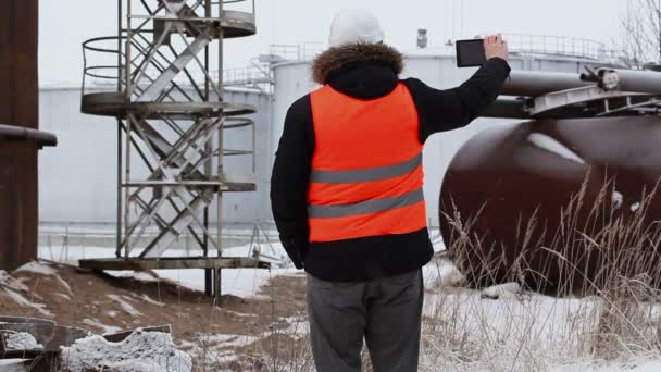 Inženýr natáčení v blízkosti olejové nádrže — Stock video