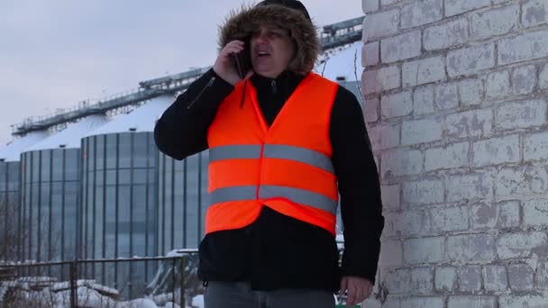 Ingenieur gebruikte slimme telefoon in de buurt van tanks in de winter — Stockvideo