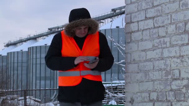 Ingeniero utiliza tableta PC cerca de los tanques en invierno — Vídeo de stock