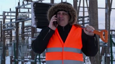 Elektrikçi ile akıllı telefon ve kar küreği kış enerji tesislerinde