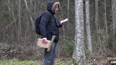 Kuşbilimci ile smartphone ve kuş kafesi tree yakınındaki