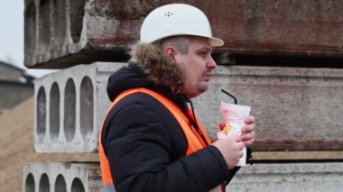 Soda içme ve patates kızartması yemek inşaat alanında çalışan