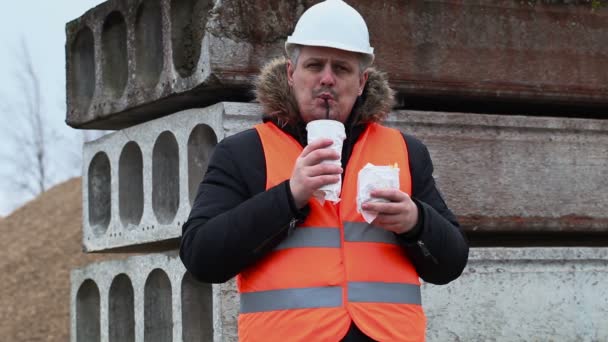 Worker with soda and french fries at construction site — Stock Video