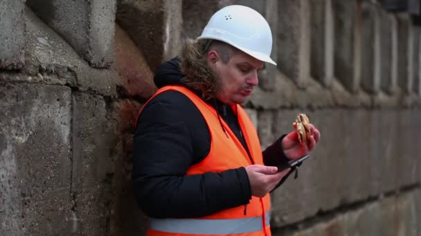 Trabajador con tablet PC y hamburguesa al aire libre — Vídeo de stock