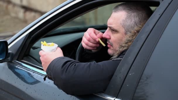 Man med pommes frites i bilen — Stockvideo