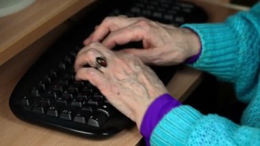 Yaşlı kadın klavye üzerinde yazıyor