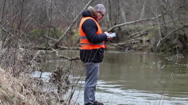 Životního prostředí inspektor kontroluje znečištění řeky v předjaří — Stock video