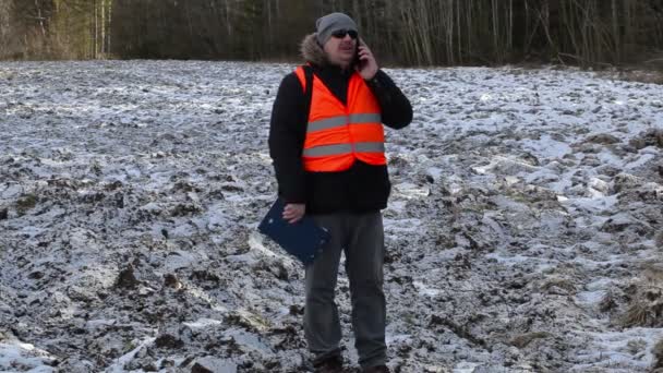 Agricultor com smartphone em campo congelado no inverno — Vídeo de Stock