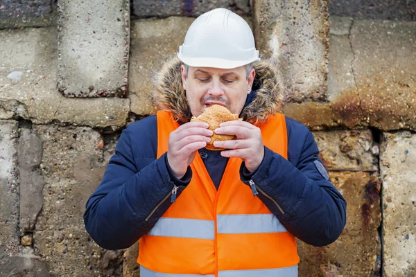 Worker eating hamburger at outdoor — Stock Photo, Image