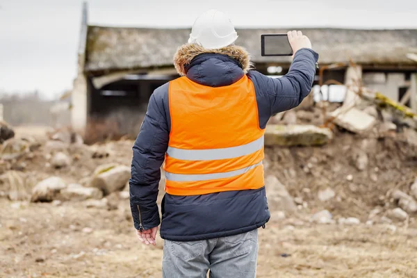 Engineer filming near to the destroyed buildings — Stock Photo, Image