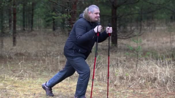Турист с избыточным весом делает упражнения для ног в лесу — стоковое видео