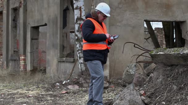 Будівельний керівник використовує планшетний ПК на території будівель до знесення — стокове відео
