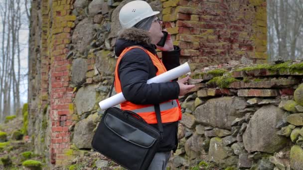 Inspecteur de bâtiment parlant sur téléphone intelligent près de vieilles ruines — Video