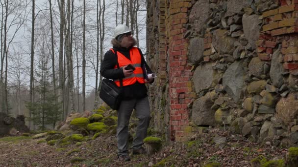Bouwen inspecteur met documentatie controleren oude ruïnes — Stockvideo