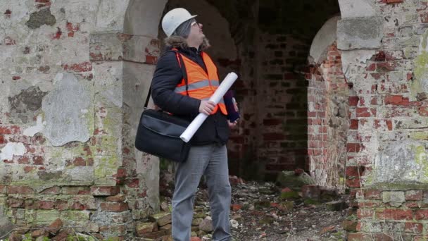 Gebouw inspecteur controleren documentatie op oude ruïnes — Stockvideo