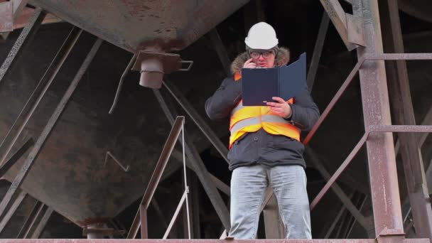 Inženýr se mobilní telefon v blízkosti nádrže — Stock video