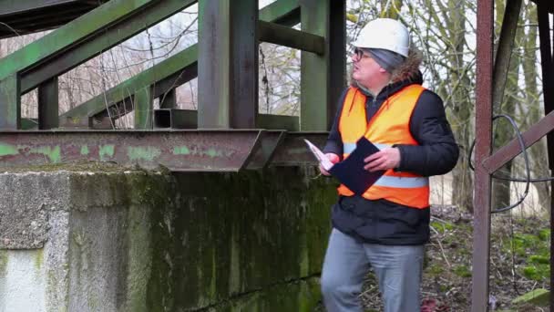 Ingenieur met documentatie in oude fabriek — Stockvideo