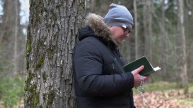 İncil okuma ve ağacın yanında dua tespih adamla 